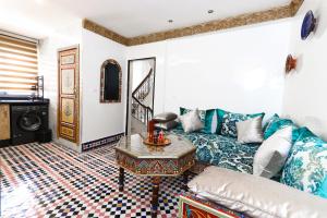 a living room with a couch and a table at Dar Ibn Majdoub Lala aicha & Alia in Fès