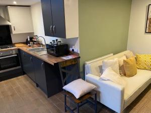 a kitchen with a couch and a kitchen with a sink at Stylish Bungalow upto 6 guests in Caversham