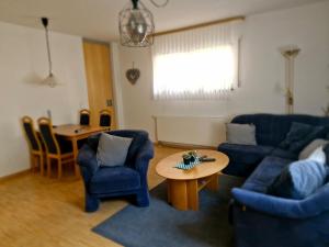 a living room with blue chairs and a table at Ferienbutzen Harz Pfingstanger, Herzberg in Herzberg am Harz