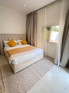 a bedroom with a bed with yellow pillows and a window at Beautiful private villa with pool in Dubai +46 photos