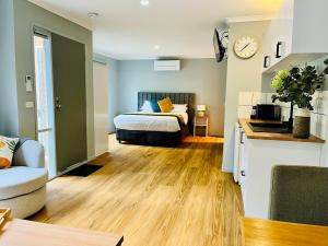 a bedroom with a bed and a kitchen with a clock at Marengo Beach Studios- Pet Friendly in Marengo