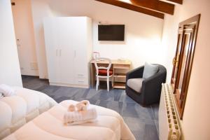 a room with two beds and a chair and a desk at La Plaza B&B in Cavaglià