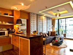 a kitchen and a living room with a couch at Rashmi's Plaza Hotel Vientiane in Vientiane