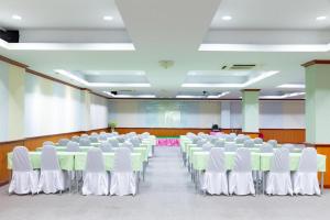 a room with rows of tables and white chairs at Rimnam Hotel Suk Sawat 70 in Ban Khru Nok