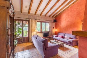 ein Wohnzimmer mit zwei Sofas und einem Fernseher in der Unterkunft Dalt La Figuera in La Higuera