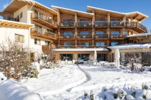 a building in the snow with snow covered grounds at Blu Hotel Natura & Spa - Adults Only in Folgaria