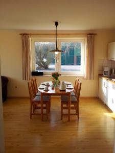 Una mesa y sillas en una cocina con ventana. en "Höper Mittelhof" Ferienhaus Nr 2, en Lemkendorf
