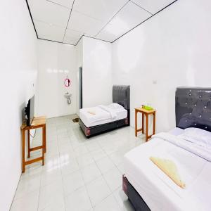 Postel nebo postele na pokoji v ubytování Kempu Tigan Homestay Berastagi Mitra RedDoorz