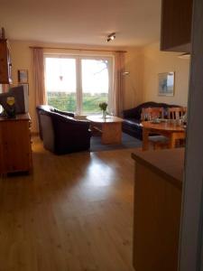 una sala de estar con un sofá y una mesa en "Höper Mittelhof" Ferienhaus Nr 1, en Lemkendorf