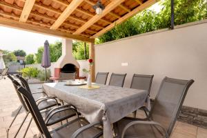 a table and chairs on a patio with a fireplace at New villa with pool, 600 m from the beach - by TRAVELER tourist agency Krk ID 2164 in Pinezici