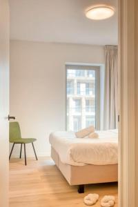 オーステンデにあるSunny Seaview Sanctuary in Ostend w Parkingのベッドと椅子と窓のある寝室