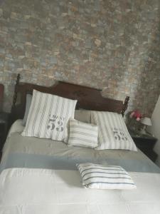 a bed with two pillows and a brick wall at Casetta Esmeralda in Praia a Mare +33 photos
