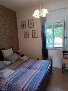a bedroom with a bed and a window and a chandelier at Casetta Esmeralda in Praia a Mare