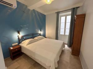 a bedroom with a bed with a blue wall at Rossetti Rosa Vieux Nice 2 bed in Nice