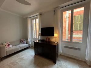 a living room with a couch and a flat screen tv at Rossetti Rosa Vieux Nice 2 bed in Nice