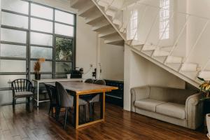 a living room with a table and chairs and a staircase at Nhà Bơ Homestay in Phan Rang