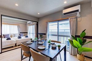 a living room with a dining table and a bedroom at 海の見える高層階グループファミリー歓迎コストコ近くThe琉球タワー9A in Yonabaru