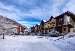 a snow covered street in a town with buildings at Blu Hotel Acquaseria in Ponte di Legno