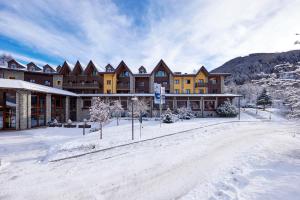 eine große Hütte im Schnee mit schneebedecktem Boden in der Unterkunft Blu Hotel Acquaseria in Ponte di Legno