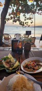 einen Tisch mit Teller mit Speisen am Strand in der Unterkunft Fullmoon Beachresort Krabi in Ao Nang Beach
