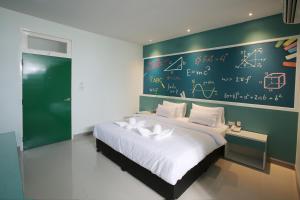 a bedroom with a large bed with a wall with mathematical equations at โรงแรมเดอะคัลเลอร์ยโสธร The Colour Hotel Yasothon in Yasothon +8 photos