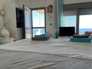 a bedroom with a large bed with a view of the ocean at Kiparissi suit in Evdilos