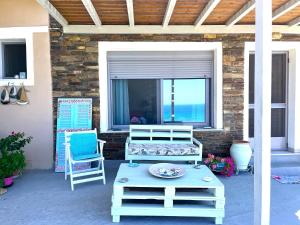 a patio with two chairs and a table and a window at Kiparissi suit in Evdilos