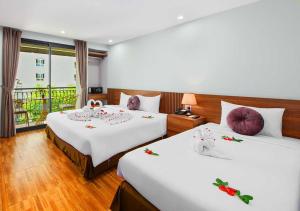 Postel nebo postele na pokoji v ubytování Family Hanoi Hotel