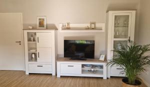 a white entertainment center with a flat screen tv at Ferienwohnung Sendelbeck in Warmensteinach