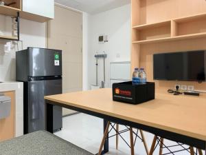 een keuken met een tafel met flessen water erop bij Relaxing 2BR at 35th Floor Tokyo Riverside PIK 2 Apartment By Travelio in Rawalembang