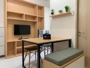 een kamer met een bureau met 2 krukken en een televisie bij Relaxing 2BR at 35th Floor Tokyo Riverside PIK 2 Apartment By Travelio in Rawalembang