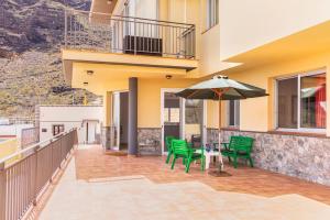 a patio with a table and an umbrella at Apartment Vista de la Cruz - Tamaimo, WIFI, BBQ in Tamaimo