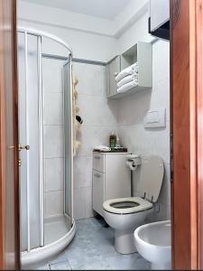 a white bathroom with a toilet and a shower at Venice Secret Garden view in Venice