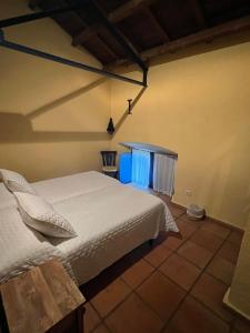 a bedroom with a white bed in a room at El Duende Casa Rural in Santo Tomé
