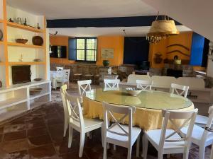 a dining room with a table and white chairs at El Duende Casa Rural in Santo Tomé