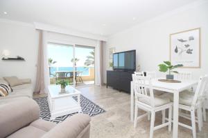 a living room with a couch and a table with a tv at Del Parque Flats Family Paradise in Rincón de la Victoria