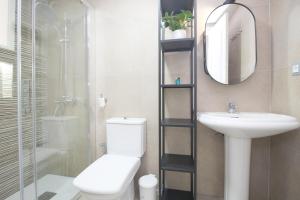 a bathroom with a toilet and a sink and a mirror at Del Parque Flats Family Paradise in Rincón de la Victoria +44 photos