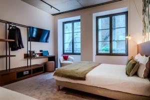 une chambre avec un lit, une télévision et des fenêtres dans l'établissement Hôtel Anne de Bretagne, à Saint-Malo 60 autres photos