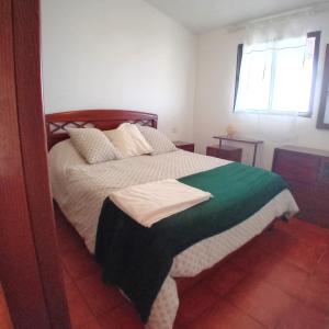 ein Schlafzimmer mit einem Bett mit einer grünen und weißen Decke in der Unterkunft Las Monteras - Quiet Rural House & BBQ, Hierro in El Pinar del Hierro