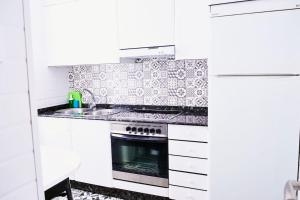 フェロルにあるApartamento Bello Piñeiroのコンロとシンクのある白いキッチン +16枚の写真