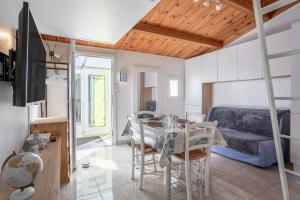 eine Küche und ein Wohnzimmer mit einem Tisch und einer Couch in der Unterkunft Studio piscine partagée in Brétignolles-sur-Mer