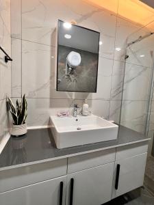 a bathroom with a white sink and a mirror at Crystal Luxury Studio At Kass 1000 in Accra