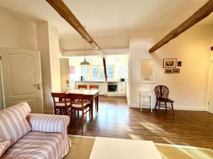 a living room and kitchen with a table and chairs at Altes Standesamt Große Wohnung in Oldsum