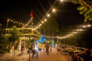 un gruppo di persone che camminano per un patio di notte di Ivory Villas and Resort a Hòa Bình Altre 170 foto
