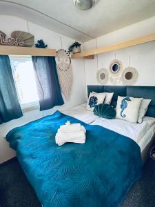 ein Schlafzimmer mit einem großen Bett und einer blauen Decke in der Unterkunft Domek holenderski Hampton in Dominice