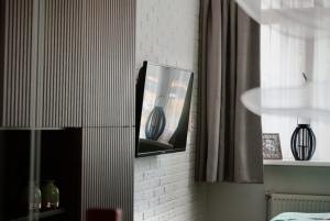 a television on a wall with a vase in it at De Drie Berken in Klazienaveen