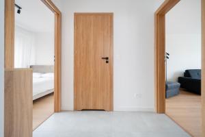 eine Holztür in einem Zimmer mit einem Schlafzimmer in der Unterkunft Górna Pleasant Apartment in Rokicie