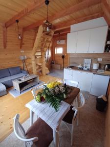 a kitchen and living room with a table with flowers on it at Red Rock in Žabljak