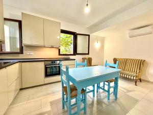 a kitchen with a blue table and chairs at La Pergola Apartments in Cardedu
