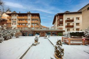 ein mit Schnee bedeckter Innenhof vor einem Gebäude in der Unterkunft Hotel Rezia in Bormio